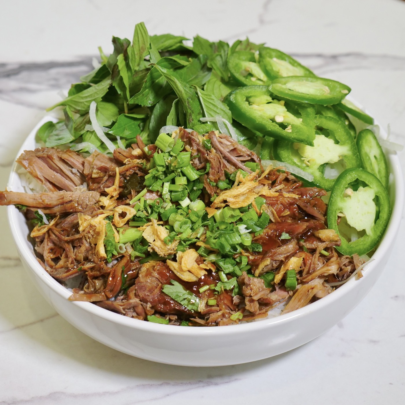 Pho Bowl topped with braised beef, Thai basil, jalapeño, scallions and crispy shallots